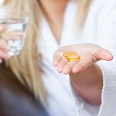 woman-holding-a-glass-of-water-and-omega-3-softgels.jpg
