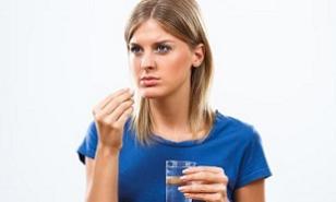 woman-holding-a-glass-of-water-and-pill.jpg