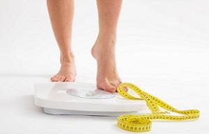 photo-of-a-woman-on-weighing-scale-with-tape-measure.jpg