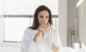 woman-holding-glass-of-water-and-bottle-of-supplement.jpg