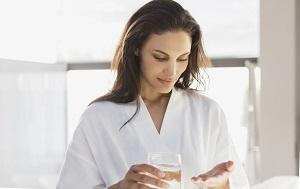 woman-holding-a-glass-of-water-and-pills.jpg