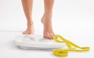 woman-on-weighing-scale-with-tape-measure.jpg
