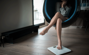 woman-stepping-her-foot-on-weighing-scale.jpg