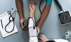 aerial view photography of person holding arm while pressing blood pressure machine