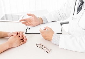 Doctor and Woman Patient Consulting on Doctors Table