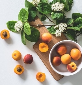 bunch of apricot fruits near flowers