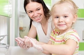 parent helping child wash hands