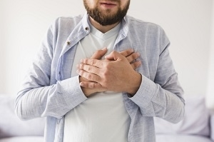 Man in grey shirt having heart attack